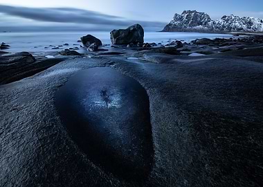 Twilight seascape with rocky shore and mountains