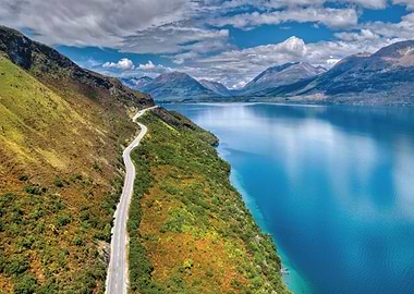 Scenic Road Along a Blue Lake and Mountains