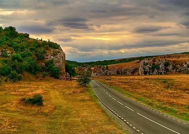 Road through rocky landscape at sunset