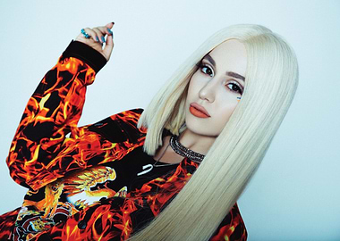 Ava Max with blonde hair and fiery jacket