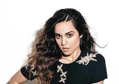 Summer Bishil with dark curly hair and embellished dress