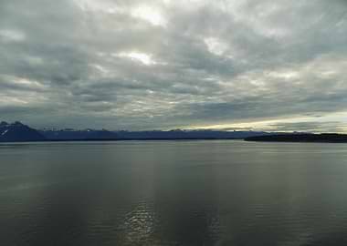 Cloudy Sky Over Water and Mountains