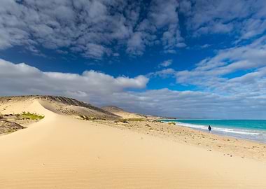 Person walking on a sandy beach by the ocean, Fuerteventura