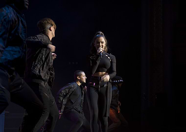 Singer performing on stage with dancers