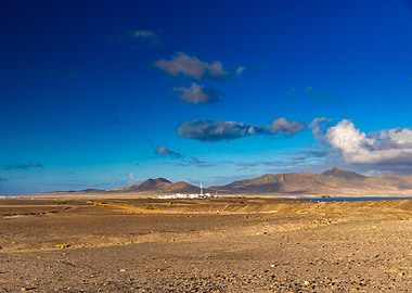Arid Landscape with Distant Mountains and Wind Turbine