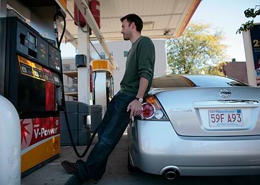 Man leaning on car at gas station