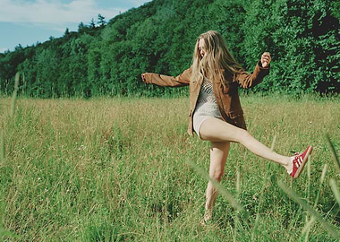 Woman in field with brown jacket