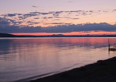 Sunset over a calm lake with mountains