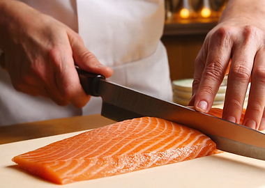 Chef slicing salmon fillet