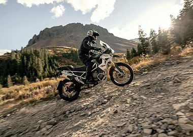 Motorcyclist riding on a rocky mountain trail