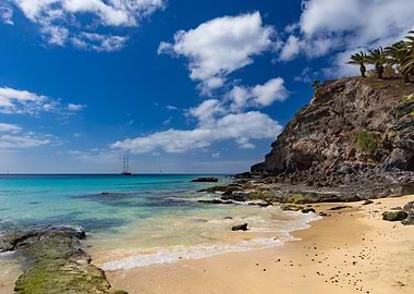 Tropical Beach with Sailboat and Cliffs