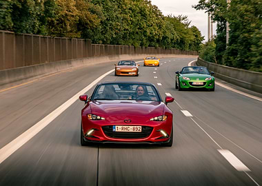 4 generations of Mazda MX-5 Driving on Highway