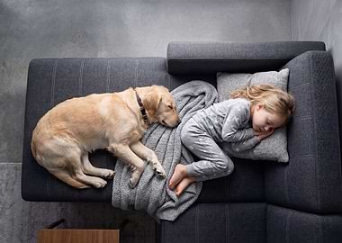 Child and dog sleeping on couch