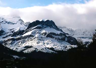 Snow-covered mountain peak under clouds