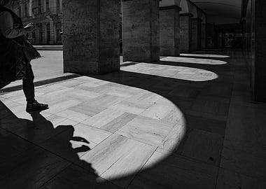 Woman walking in sunlit arcade