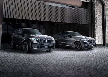 Two BMW M SUVs parked outside