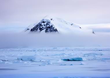 Misty Antarctic Mountain Over Ice Floes