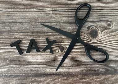Scissors cutting the word TAX