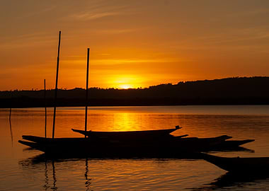 Sunset over water with silhouetted boats