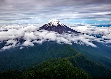 Snow-capped volcano above clouds