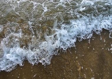 Ocean wave crashing on sandy shore