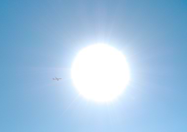 Airplane flying near the sun