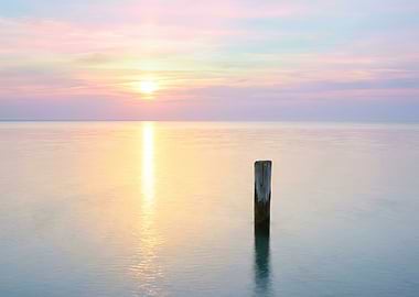 Serene Sunset Over Calm Water with Post
