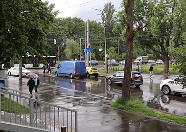 Rainy City Street with Cars and Pedestrians