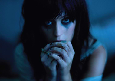 Katy Perry with dark makeup and hands clasped