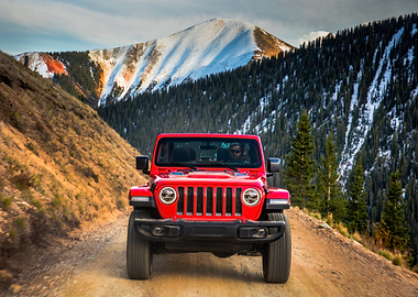 Red Jeep driving on mountain road