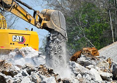 Excavator dumping shot rock