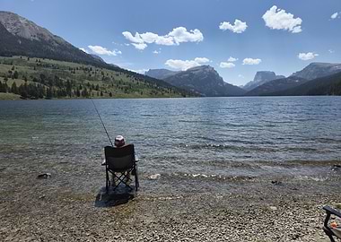 Person fishing near sweetwater valley and mountains