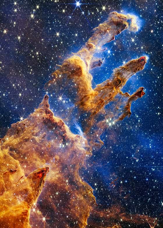 Embark on an astronomical journey with Pillars of Creation, a captivating digital artwork inspired by the iconic celestial feature captured by the James Webb Telescope. This piece masterfully portrays towering nebula formations, bathed in a radiant interplay of golden and amber light against the velvety backdrop of deep-space blues, adorned with glittering stars. 